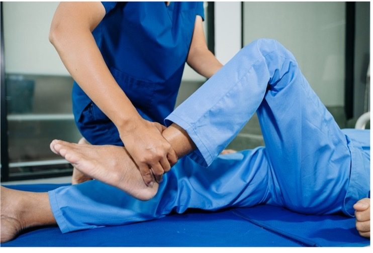 Doctor examining and treating a patient's ankle affected by chronic gout.